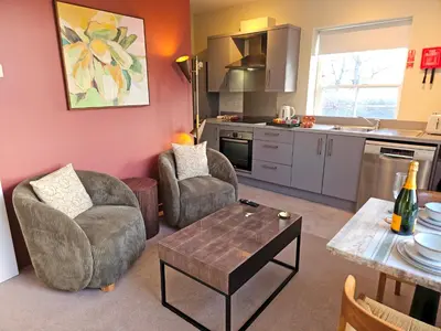 a living room with two chairs and a table at Contemporary first-floor apartment close to town - Pass the Keys in Shrewsbury