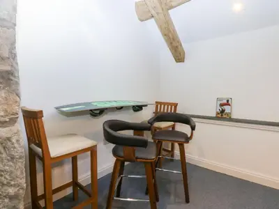 two chairs and a table with a cross on the wall at Yr Hen Felin in Dyffryn