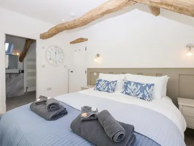 a bedroom with two beds and a clock on the wall at Yr Hen Felin in Dyffryn