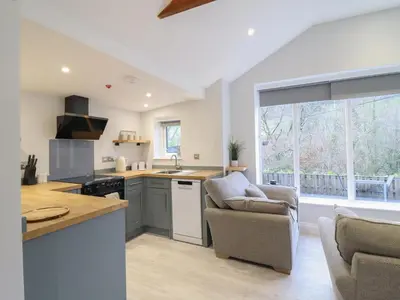 a kitchen with a couch and two chairs in a room at Lodge at Nadur in Machynlleth