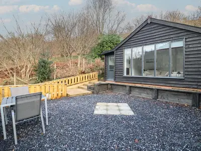 a house with a table and chairs in front of it at Lodge at Nadur in Machynlleth