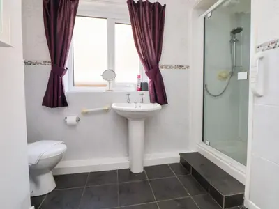 a bathroom with a sink and a toilet and a window at Castellolwg in Llangollen