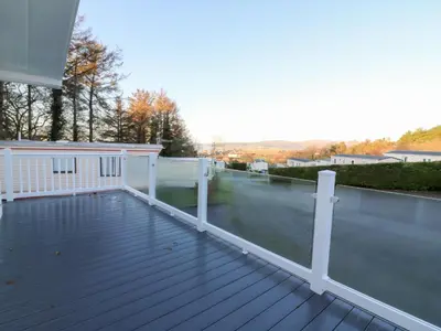 a deck with white railings on a house at Beechwood Lodge in Borth