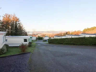 an empty road with a camper parked on the side at Beechwood Lodge in Borth