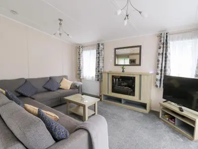 a living room with a couch and a television at Beechwood Lodge in Borth