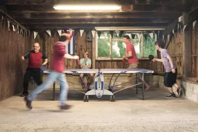 a group of people standing around a ping pong table at The Granary - Wild Swimming, Sauna, Peace & Quiet, Nr Bala in Corwen