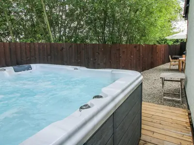 a hot tub in a backyard with a wooden fence at 1 Clarkes Lane in Oswestry