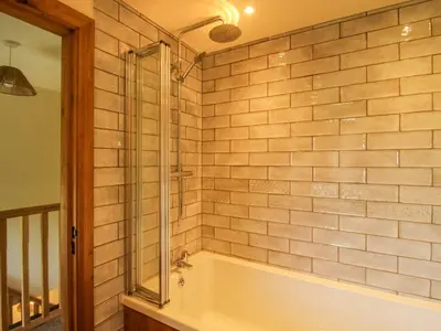 a bathroom with a tub and a glass shower at 1 Clarkes Lane in Oswestry