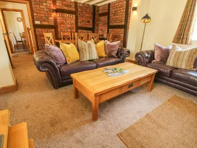 a living room with leather couches and a coffee table at 1 Clarkes Lane in Oswestry