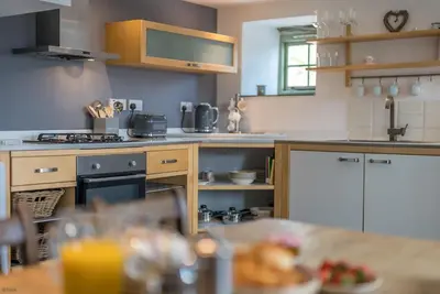 a kitchen with a table with a plate of food at Pengwern in Cerrigydrudion