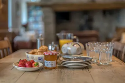a wooden table with a plate of food and a bowl of strawberries at Pengwern in Cerrigydrudion