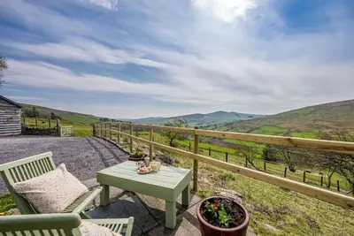 a table and chairs on a balcony with a view at Pengwern in Cerrigydrudion