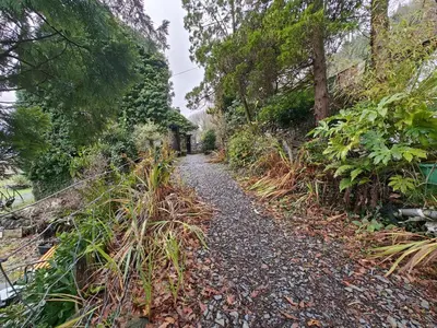 a gravel path with plants on the side of a hill at 2 Bed in Llanelltyd oc-s34505 in Llanelltyd