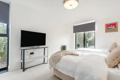 a white bedroom with a bed and a flat screen tv at 3 Bed in Leominster oc-w34380 in Leominster