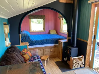 a bedroom with a bed and a stove in a room at 1 Bed in Llanfihangel-y-Creuddyn oc-c34624 in Llanfihangel-y-creuddyn