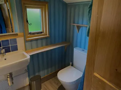 a bathroom with a toilet and a sink and a window at 1 Bed in Llanfihangel-y-Creuddyn oc-c34624 in Llanfihangel-y-creuddyn