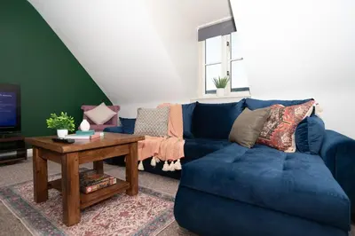 a blue couch in a living room with a table at Professionals welcome - Near Town Centre - Free Parking-Sleeps 4 in Shrewsbury