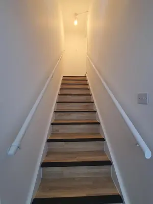 a staircase in a room with white walls and wooden floors at FLAT 2 Seven Cambrian Square First Floor Flat in Newtown