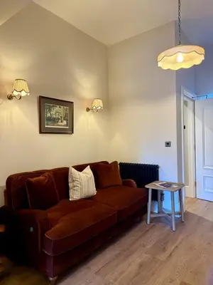 a living room with a brown couch and a table at Spacious Luxury Apartment in the Heart of Shrewsbury Sleeps 6 in Shrewsbury