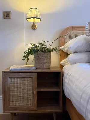 a nightstand with a plant on it next to a bed at Spacious Luxury Apartment in the Heart of Shrewsbury Sleeps 6 in Shrewsbury