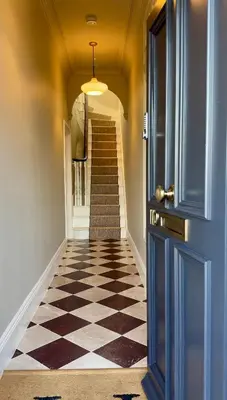 a hallway with a checkered floor and a blue door at Spacious Luxury Apartment in the Heart of Shrewsbury Sleeps 6 in Shrewsbury