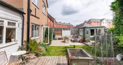 a backyard of a house with a wooden deck at Spacious 4 bed home to sleep 9, parking for 4 cars in Shrewsbury