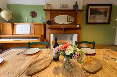 a wooden table with a vase of flowers on it at Spacious 4 bed home to sleep 9, parking for 4 cars in Shrewsbury