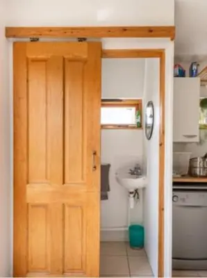 a bathroom with a wooden door and a sink at Spacious 4 bed home to sleep 9, parking for 4 cars in Shrewsbury