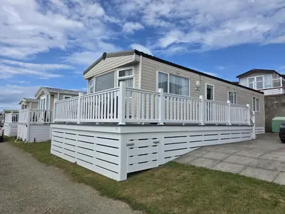 a house with a large deck on the side of it at Premium 3 Bedroom Static Caravan with Sea Views Aber Bay in Aberystwyth