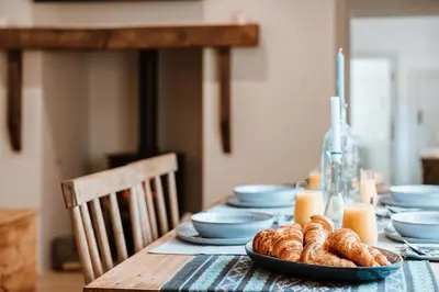 a table with blue dishes and croissants on it at Little Whitley - Luxury Country Cottage in Shrewsbury