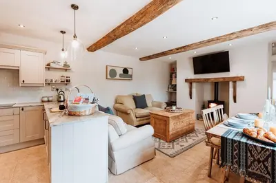 a kitchen and a living room with a table at Little Whitley - Luxury Country Cottage in Shrewsbury