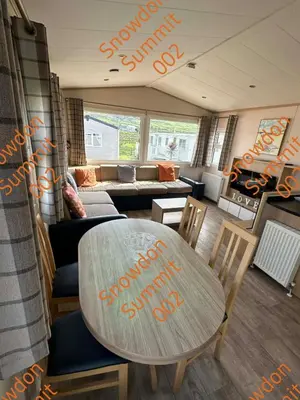 a living room with a table and a couch at Snowdon Summit 002 in Barmouth