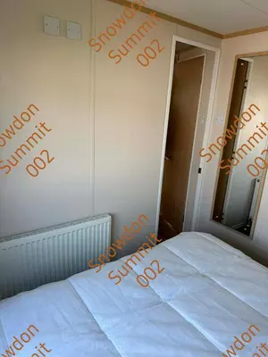 a bedroom with a bed with the word saturday written on the wall at Snowdon Summit 002 in Barmouth