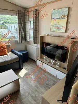 a small living room with a couch and a tv at Snowdon Summit 002 in Barmouth