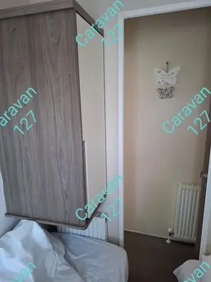 a bedroom with a cupboard and a bed in a room at Caravan 127 in Barmouth