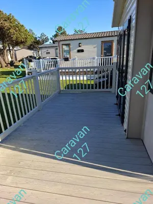 a front porch of a house with a white fence at Caravan 127 in Barmouth
