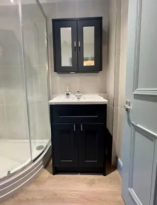 a black bathroom with a sink and a shower at Charming 2 Bed House in Central Shrewsbury in Shrewsbury