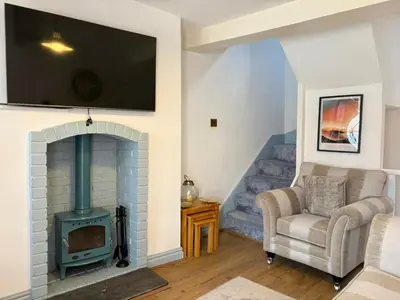 a living room with a fireplace with a tv above it at Charming 2 Bed House in Central Shrewsbury in Shrewsbury
