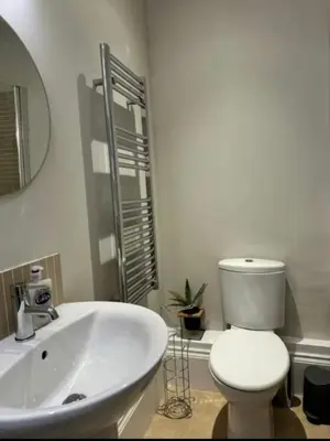 a white bathroom with a toilet and a sink at Swn Y Mor 3 Aberystwyth in Aberystwyth