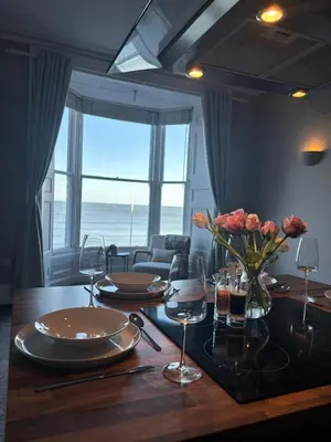 a dining room table with a view of the ocean at Swn Y Mor 3 Aberystwyth in Aberystwyth
