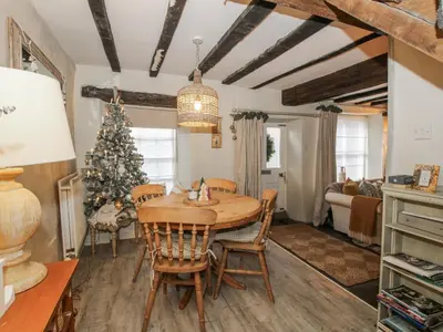 a dining room with a table and a christmas tree at 8 Welsh Street in Bishops Castle