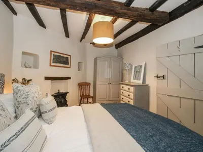 a bedroom with a white bed and a barn door at 8 Welsh Street in Bishops Castle