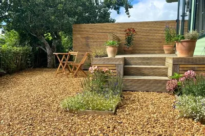 a garden with a bench and a table and flowers at Lavender Lodge