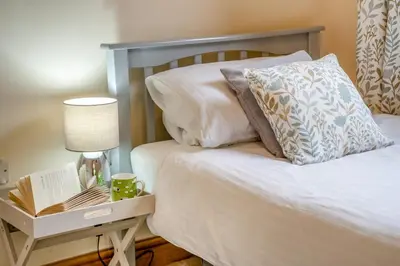 a bed with a lamp and a nightstand with a book at 2 Bed in Brecon oc-r33603 in Lower Chapel