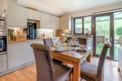 a kitchen with a wooden table with chairs around it at 2 Bed in Brecon oc-r33603 in Lower Chapel
