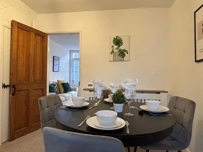 a dining room with a black table and chairs at 2 bedroom house 12mins walk to town in Shrewsbury