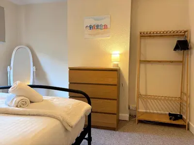 a bedroom with a bed and a dresser and a mirror at 2 bedroom house 12mins walk to town in Shrewsbury