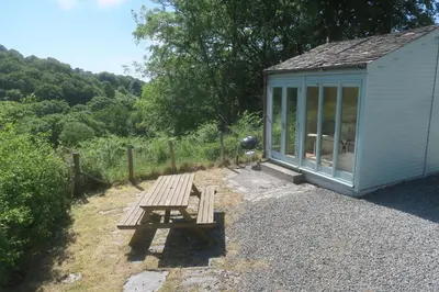 a wooden bench sitting next to a shed at Welsh Hideaways in Pentre-briwnant