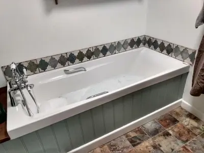 a bathtub in a bathroom with a green and white at Welsh Hideaways in Pentre-briwnant