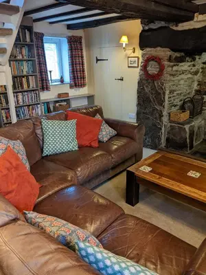 a living room with leather couches and a stone fireplace at Welsh Hideaways in Pentre-briwnant